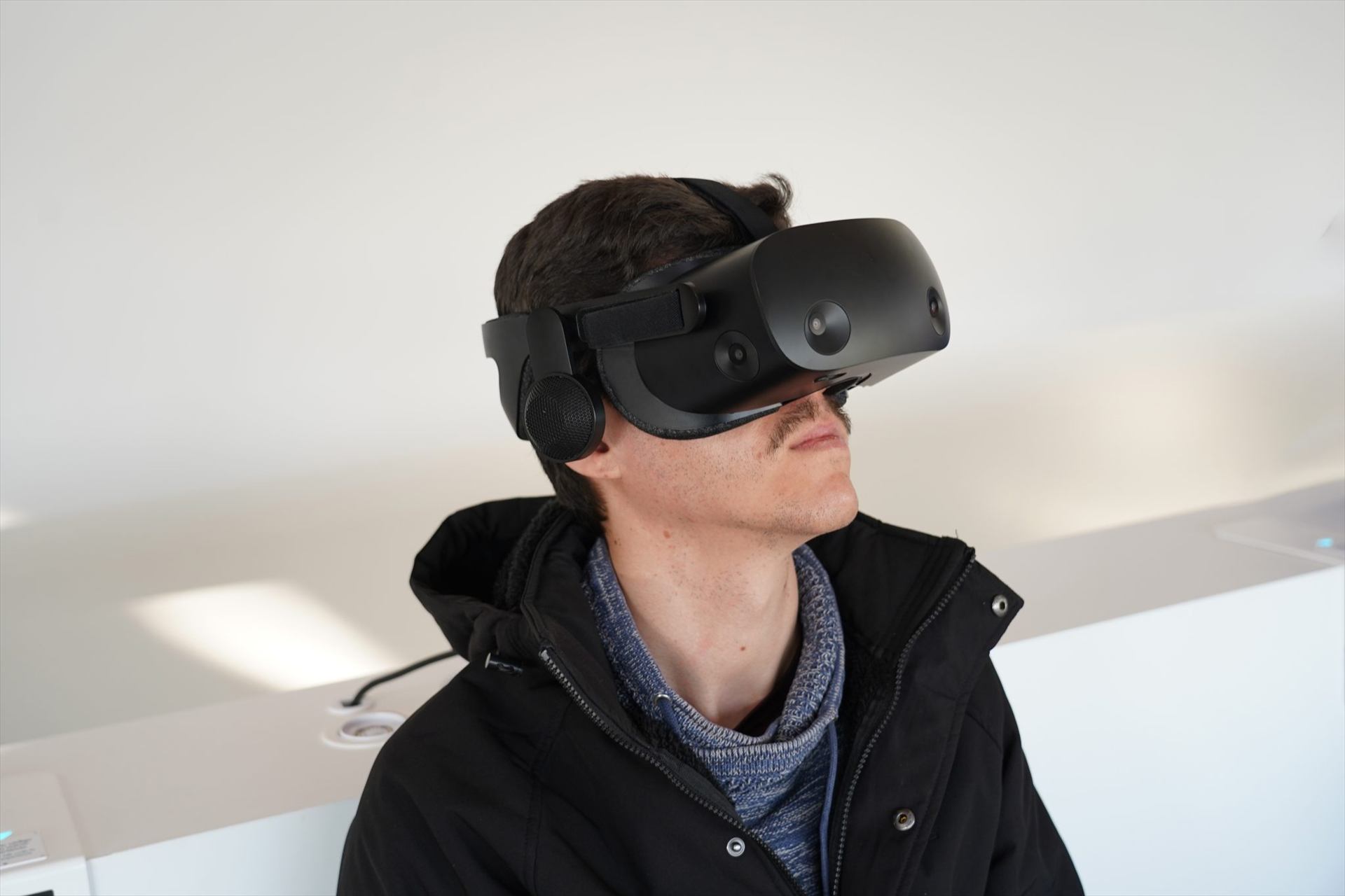 Людина в чорному VR-шоломі дивиться вгору